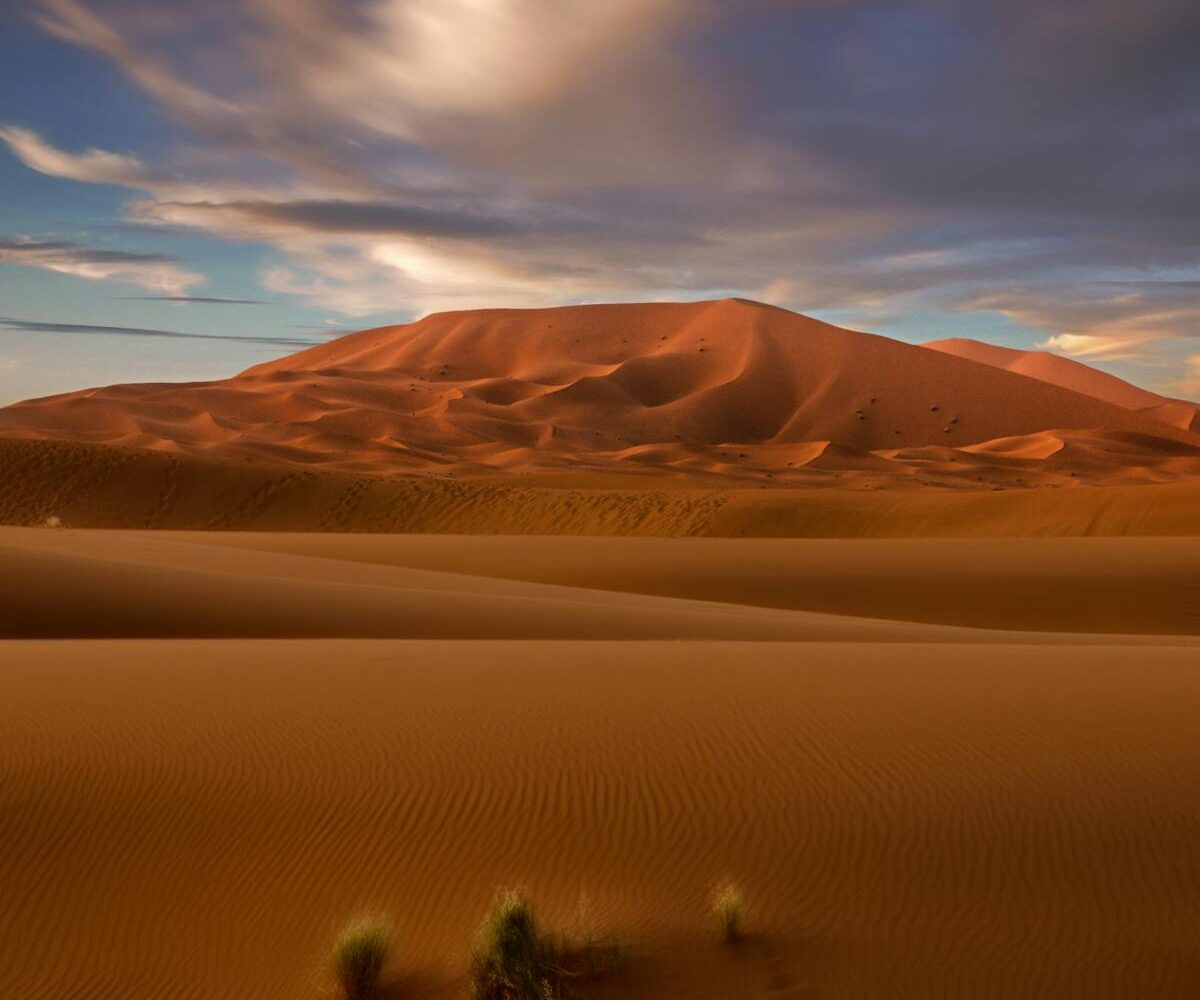 Stunning view of Moroccan sand dunes under a vibrant blue sky, highlighting the beauty of the Sahara Desert.