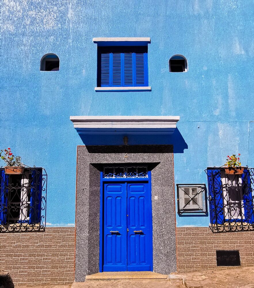 blue wooden door on blue concrete building